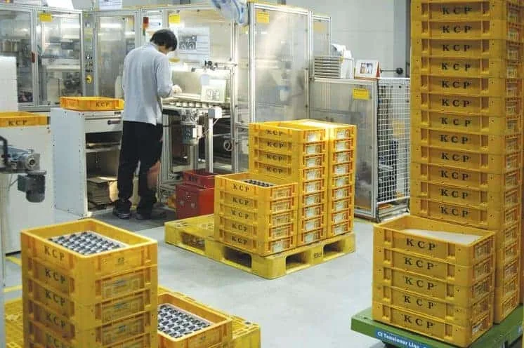 Thùng nhựa in chữ trên thành thùng xếp chồng trên pallet trong nhà máy
