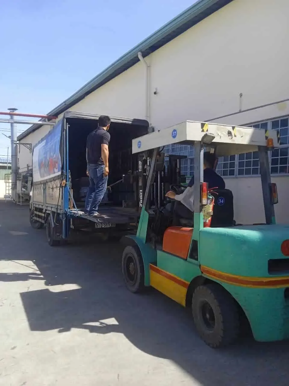 Truck and forklift delivering an ICD T1650F stretch wrapper to a customer's warehouse at Viet Huong Industrial Park, Binh Duong