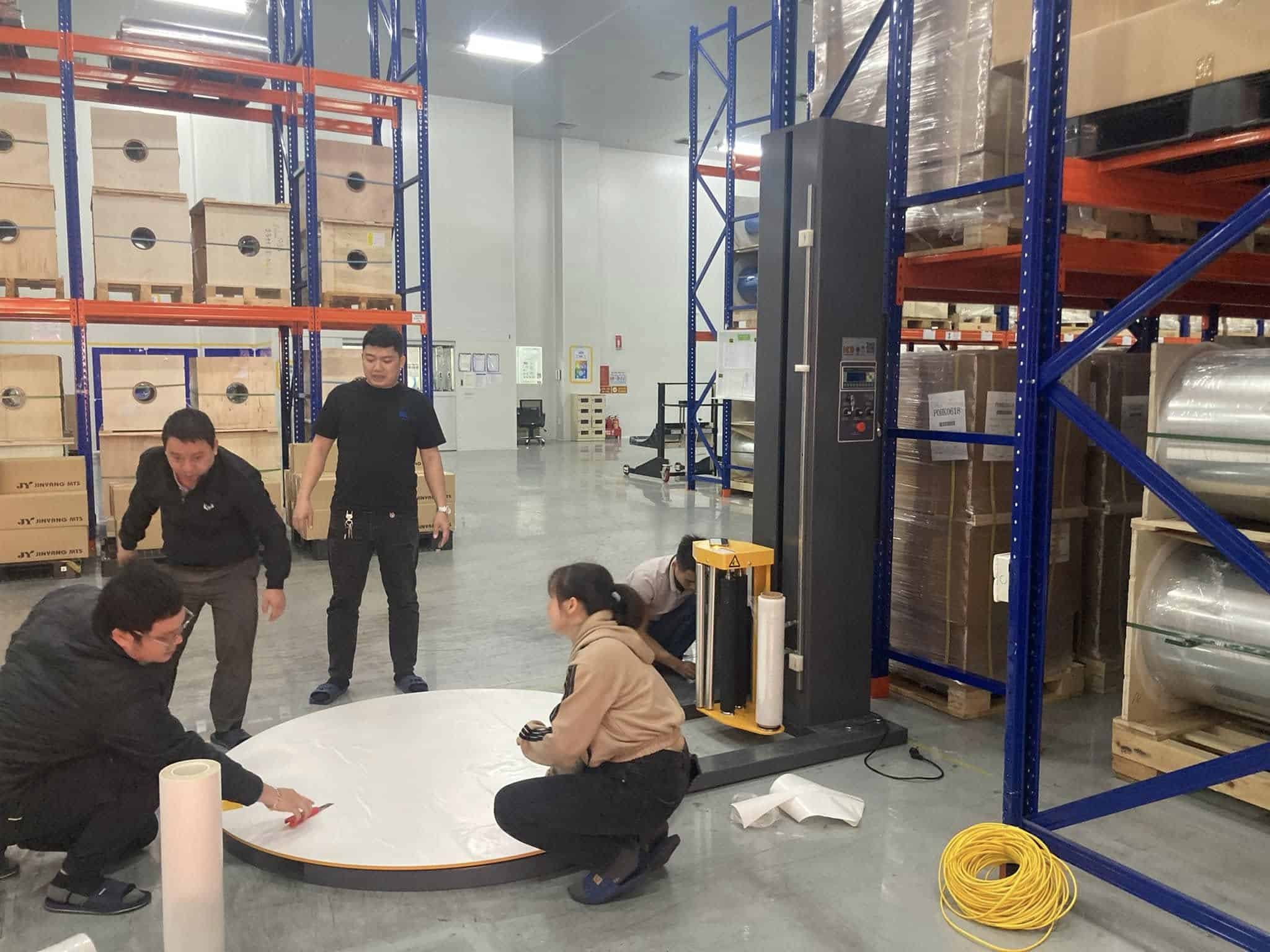 Đội ngũ cùng nhân viên khách hàng lắp mâm xoay của máy quấn màng trong kho