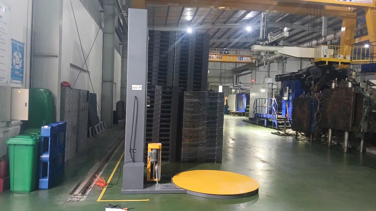 Máy quấn pallet ICDT1650F lắp trong xưởng nhà máy sản xuất pallet nhựa tại Hưng Yên, cạnh chồng pallet đen