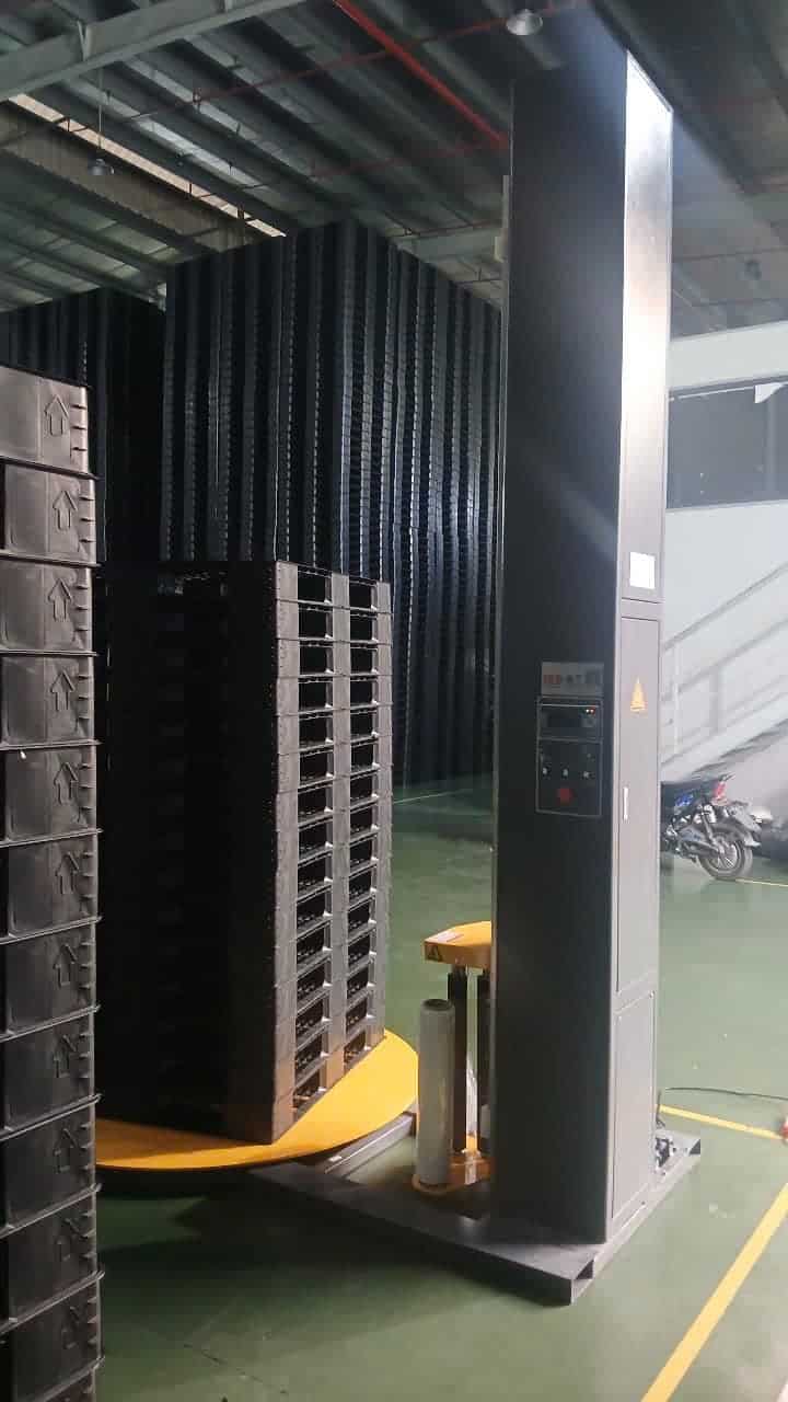 Chồng pallet nhựa đen đặt trên mâm xoay của máy quấn ICDT1650F