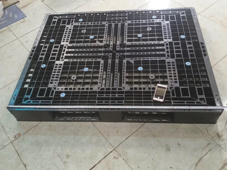 Pallet nhựa đen 1200 x 1000 mm đặt trên sàn để đo kích thước