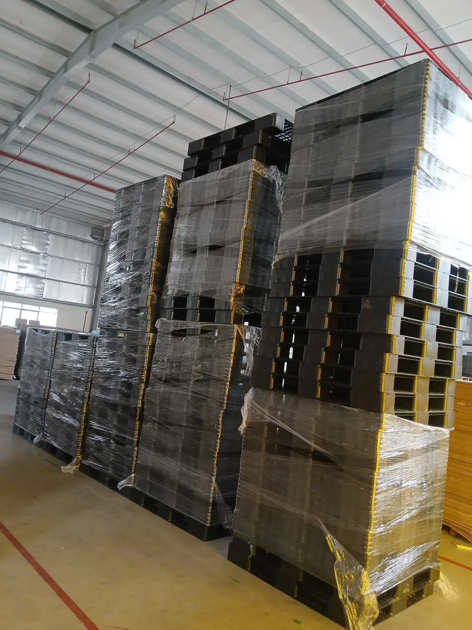 Pallet nhựa cũ ICD bọc màng PE xếp cao trong kho chờ xuất