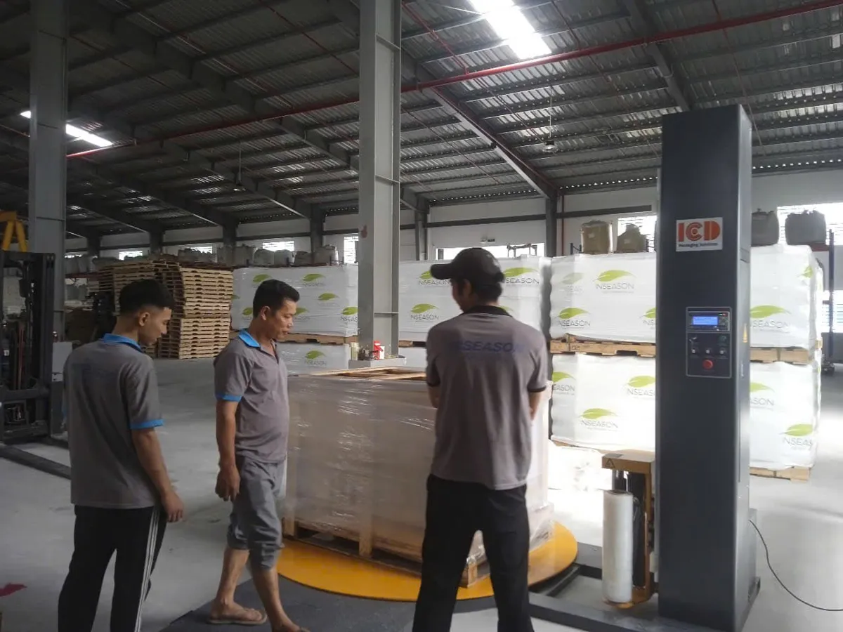 ICD-T1650F turntable pallet wrapping machine at a customer's plant with a staff member checking the load