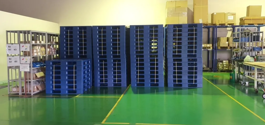 Pallet nhựa xanh dương xếp chồng trong nhà xưởng sàn epoxy của khách hàng