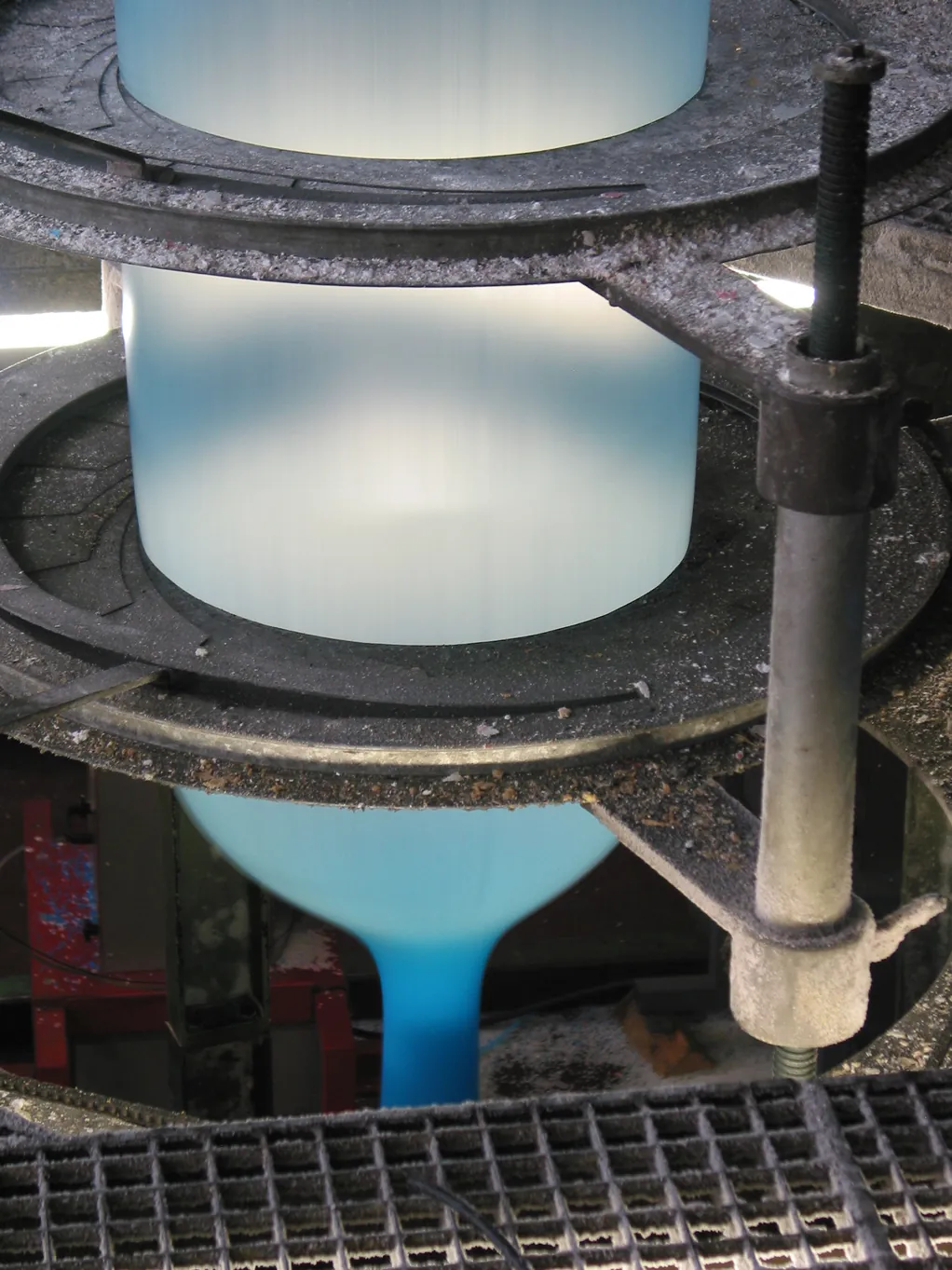 Blue PE film bubble being blown upward through cooling rings on a blown-film extrusion line