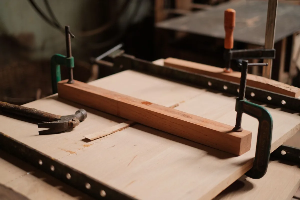 A panel made of many strips clamped tightly with steel clamps in a joinery workshop