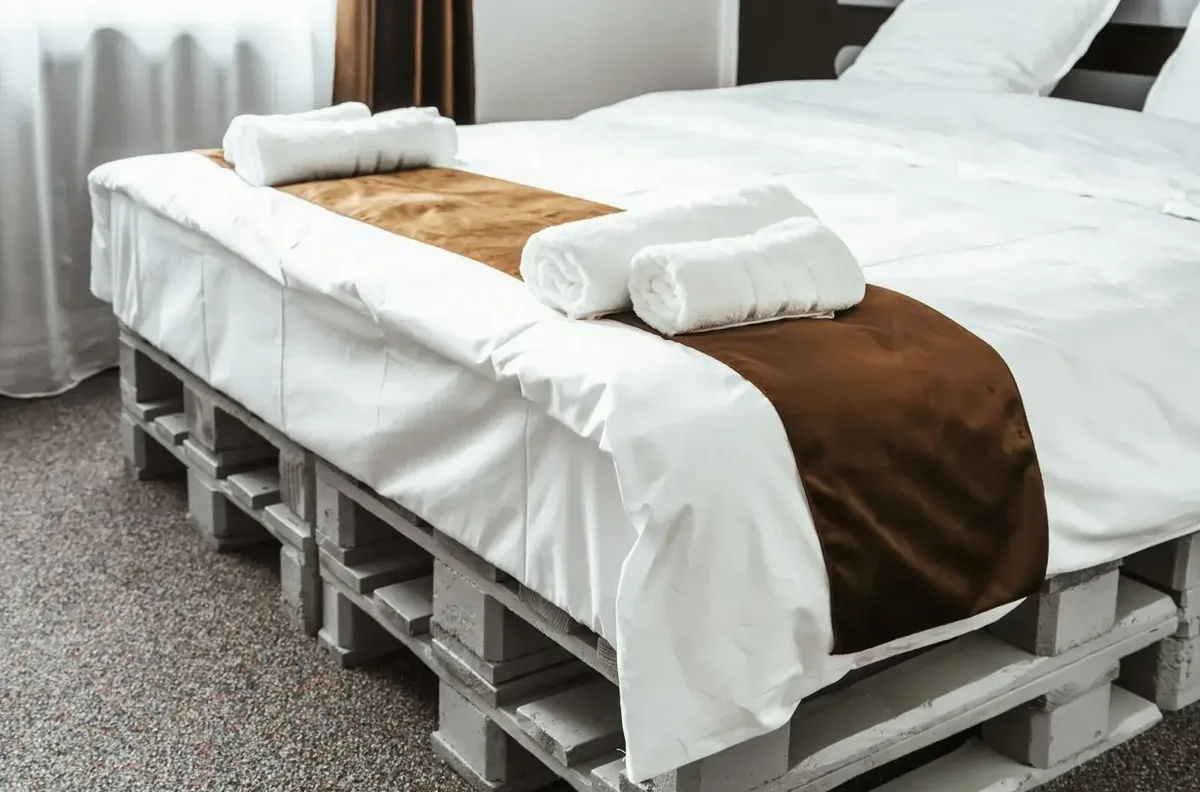 Giường ghép từ pallet gỗ sơn trắng nhìn từ góc ngang