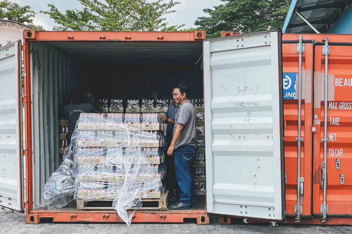 Nhân viên kiểm hàng xếp trên pallet bọc màng trong container