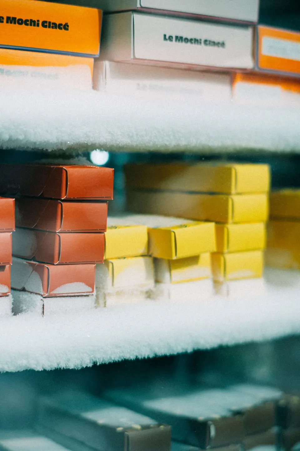 Boxes of goods on shelves in a freezer cabinet, covered with a layer of frost