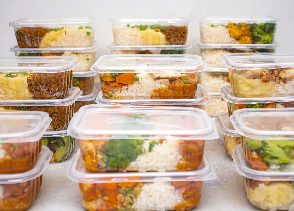 Hộp nhựa đựng cơm và rau củ xếp chồng nhiều tầng