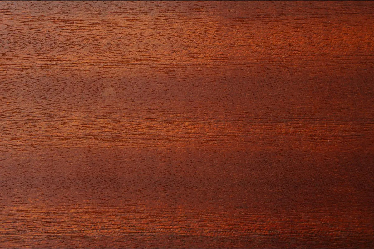 A reddish-brown wood surface with fine grain