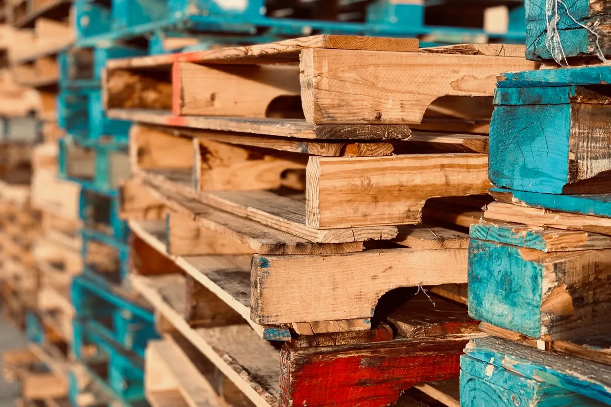 Pallet gỗ cũ bong sơn, nhiều màu xếp chồng cận cảnh