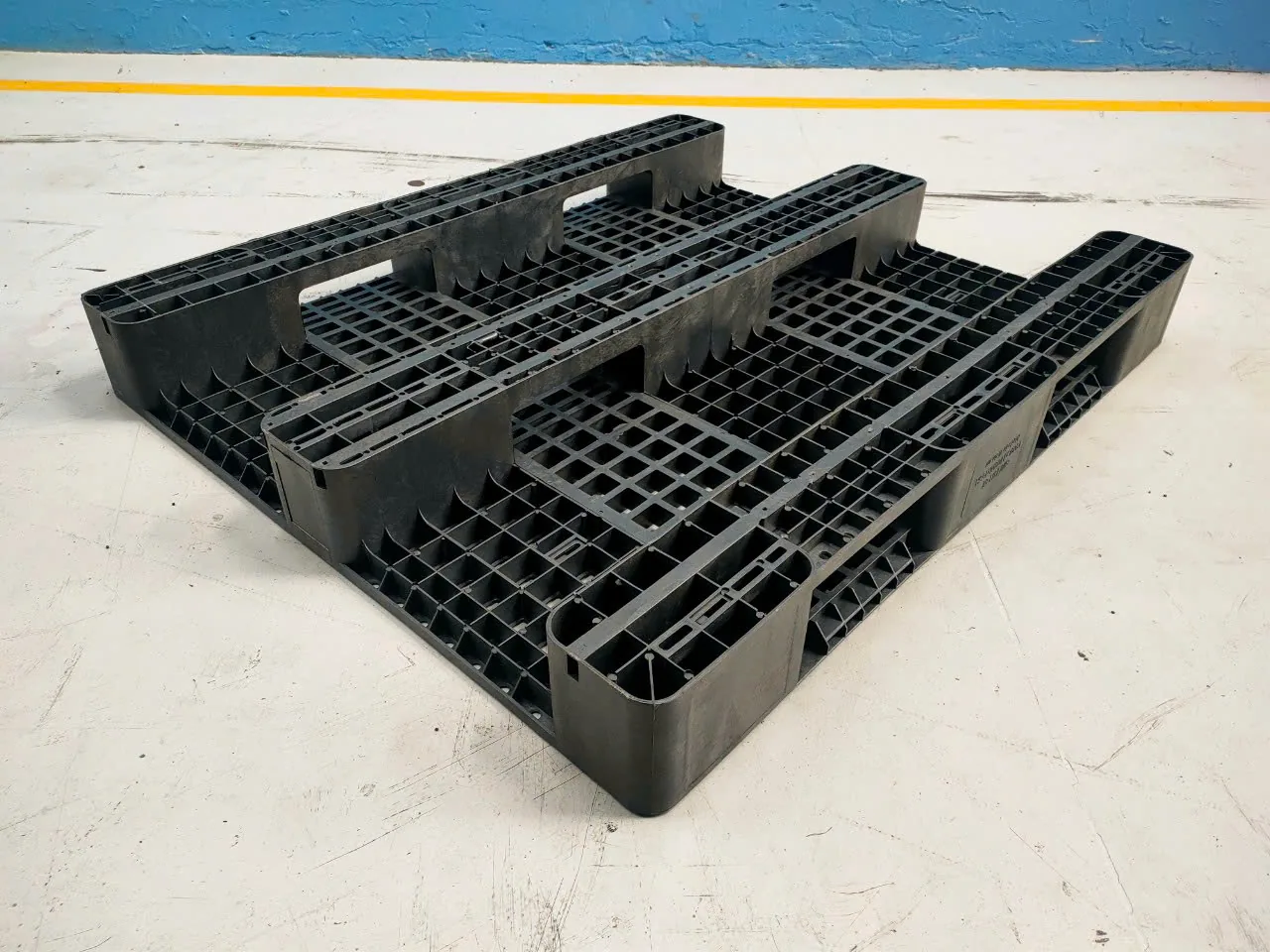 Mặt đáy pallet nhựa 3 chân 1300x1100x155 mm màu đen, ba thanh chân có cửa khoét cho càng xe nâng