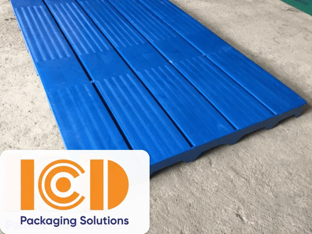 Tấm pallet nhựa lót sàn mặt nan màu xanh dương có gân chống trượt đặt trên nền xi măng