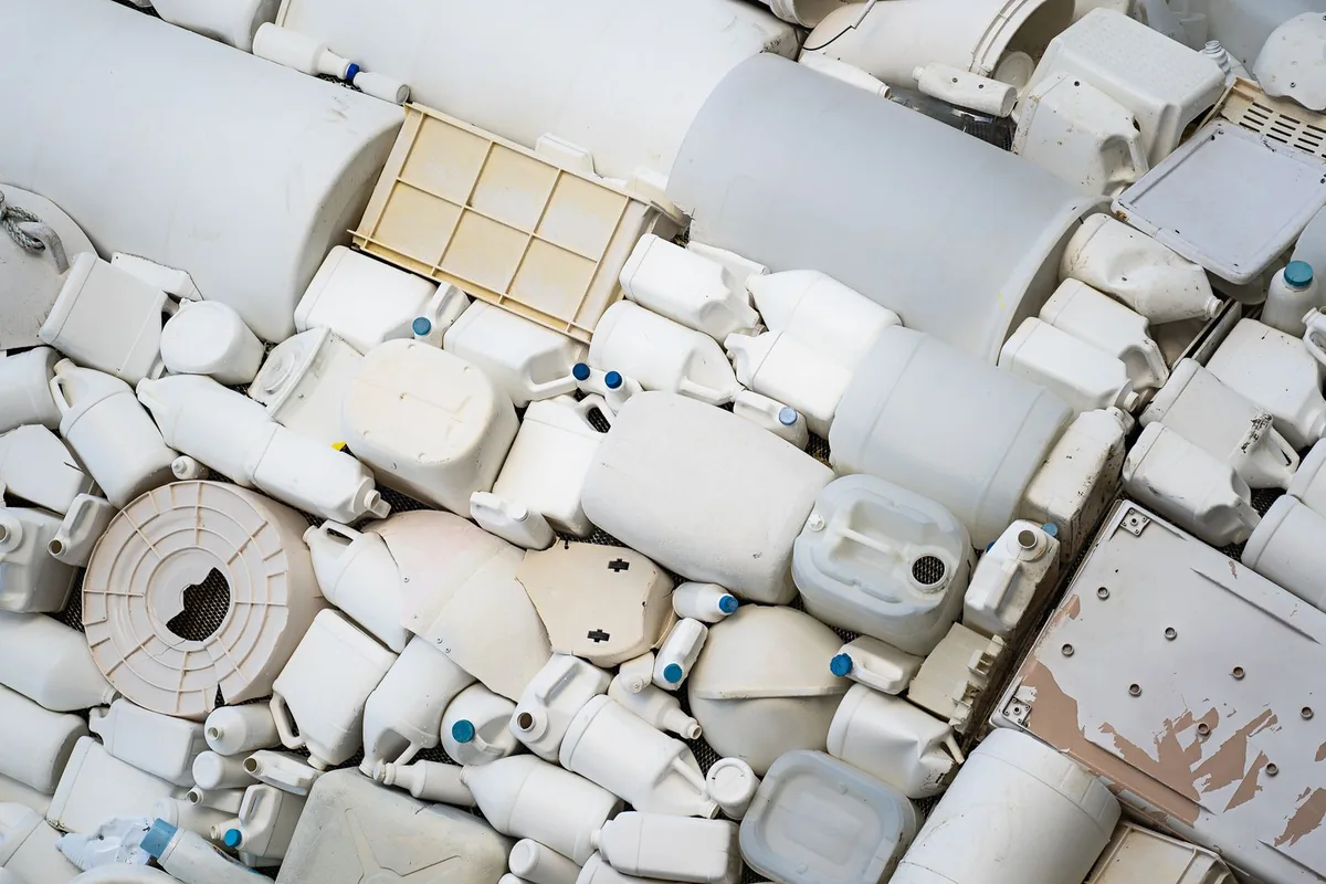 Đống can nhựa HDPE trắng đã qua sử dụng chờ tái chế