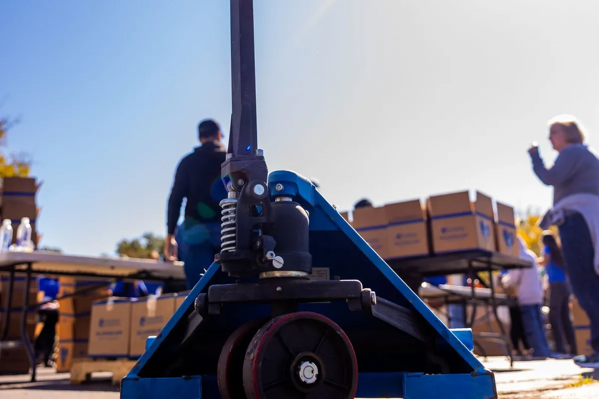 Xe nâng tay kéo pallet chất thùng hàng ngoài trời