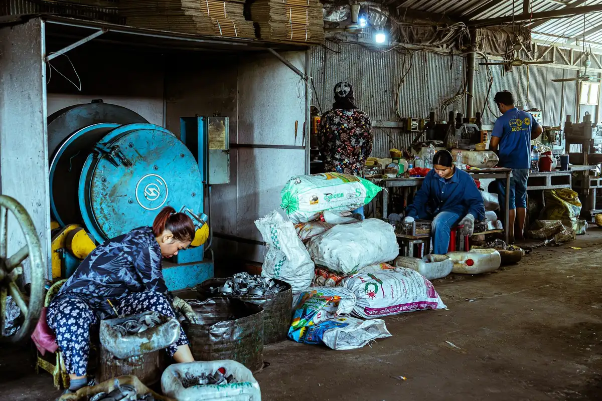 Workers sorting plastic scrap at a recycling plant